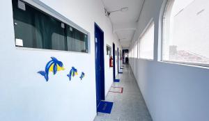 a hallway of a building with blue fish on the wall at Pousada Estação do Porto in Porto De Galinhas