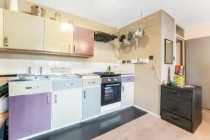 a kitchen with white cabinets and purple appliances at Pass the Keys - Modern flat in North Central London in London