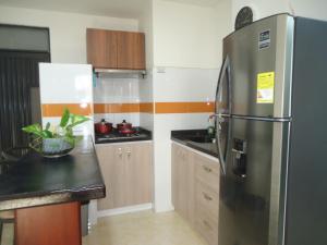 uma cozinha com um frigorífico de aço inoxidável e armários de madeira em APARTA-ESTUDIO LA TOMA em Neiva