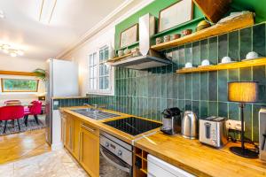 - une cuisine avec des murs carrelés verts et des comptoirs en bois dans l'établissement Stylish Modern Apartement - Art, Design, Garden, Villa des Ammonites, à Meudon