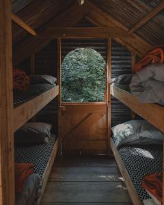 Habitación con 3 literas y ventana. en Architectural Danish Cabin surrounded by nature en Treknow