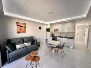 a living room with a couch and a table and chairs at Precioso y nuevo apartamento de 1 habitación en Mareverde in Adeje
