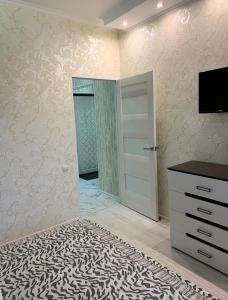 sypialnia z lustrem, komodą i drzwiami w obiekcie Кылышбай акына w mieście Taraz