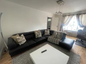 a living room with a black couch and a table at Mayfield square in Belfast