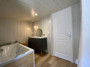 OrcetMaison - 4 Chambres - 10 couchages - 2sdb的一间带水槽和浴缸的浴室以及一扇门 更多2张照片