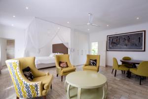 a bedroom with a bed and a table and chairs at Lovely deluxe with outdoor pool and gym - 2145 in Victoria Falls