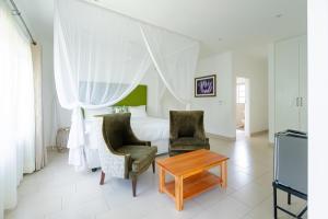 a bedroom with a bed and two chairs and a table at Lovely deluxe with outdoor pool and gym - 2145 in Victoria Falls