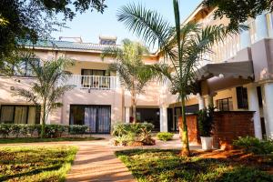 a building with palm trees in front of it at Lovely deluxe with outdoor pool and gym - 2145 in Victoria Falls