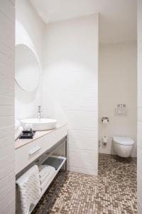 a white bathroom with a sink and a toilet at Jump INN Hotel Belgrade in Belgrade