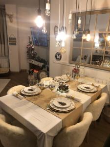 a dining room with a table with chairs and a christmas tree at Apartamento alpino Plaza de Andalucía a pie de pistas in Sierra Nevada