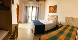 um quarto de hotel com duas camas e uma janela em Mar Egeu Arte & Pouso em Peruíbe