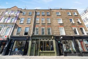 a large brick building on a city street at Superb One Bedroom Apartment in Soho in London