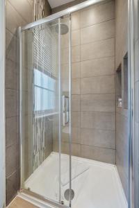 a shower with a glass door in a bathroom at Superb One Bedroom Apartment in Soho in London