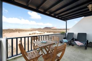 a balcony with a table and chairs on a beach at Apartamento Cabo in Caleta de Sebo