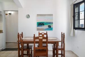 uma sala de jantar com uma mesa e cadeiras e um quadro em Apartamento Cabo em Caleta de Sebo