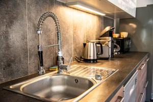 a kitchen counter with a sink in a kitchen at Loft 90 m2 cosy au calme avec terrasse et parking in Avignon
