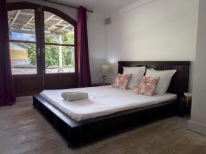 a bedroom with a large bed with a window at Villa Jouanacaera in Le Carbet