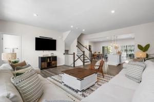 uma sala de estar com um sofá branco e uma televisão em Luxurious 3 Story Townhome! The Dye at Barefoot Resort 402- Sleeps 12! em North Myrtle Beach