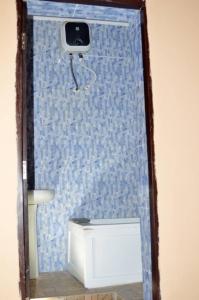 La salle de bains est pourvue d'un mur carrelé bleu et d'une caméra. dans l'établissement Apartments Complex with Parking Ibadan Oluyole Extension - Sharp Corner, à Ibadan