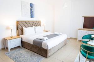a bedroom with a bed and a table and chairs at MURJAN JBR Apartments by HAPPY SEASON in Dubai