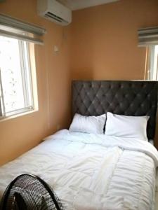 um quarto com uma cama grande com lençóis brancos e uma janela em Apartments Complex with Parking Ibadan Oluyole Extension - Sharp Corner em Ibadan