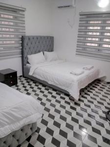 - une chambre avec 2 lits et un sol en damier dans l'établissement Apartments Complex with Parking Ibadan Oluyole Extension - Sharp Corner, à Ibadan