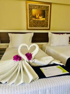 a hotel room with two beds with a wedding dress at Pousada o Caribe de Maragogi in Maragogi
