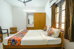 1 dormitorio con cama y ventana en FabHotel Joy's Residency en Coimbatore