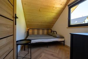 um pequeno quarto com uma cama e uma janela em Domki Jasicówka pod Łysą Górą em Limanowa