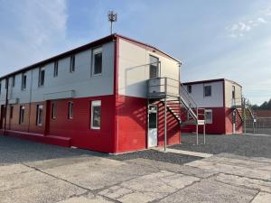 a red and white building with a staircase on it at Ubytovna SDC in Valcha