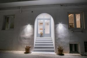 an entrance to a building with a white door and stairs at Helmos Premium Studio in Naxos Chora