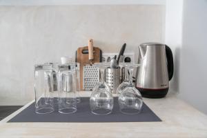 un grupo de copas de vino sentado en la parte superior de un mostrador en Helmos Cozy Studio, en Naxos Chora