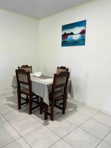 a dining room table with chairs and a painting on the wall at SICE- Apartment 1 in Meerzorg