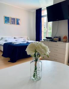 a vase with flowers on a table in a bedroom at Apartament Esperanza in Sunny Beach