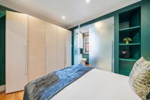 a bedroom with a white bed and green walls at Fantastic One Bedroom Apartment in Soho in London