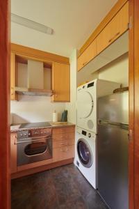 a kitchen with a refrigerator and a washing machine at Hauzify I Apartament Bella Molina in Alp