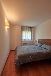 a bedroom with a large bed with a window at Hauzify I Apartament Bella Molina in Alp