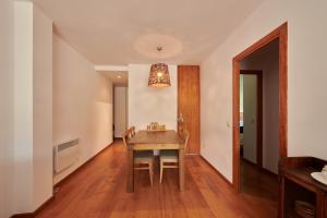 a dining room with a wooden table and a light fixture at Hauzify I Apartament Bella Molina in Alp