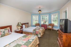 a hotel room with two beds and a television at Lakeside Inn on Lake Dora in Mount Dora
