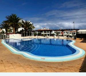 una grande piscina blu con palme e edifici di Promenade Paradise Apartment a San Miguel de Abona