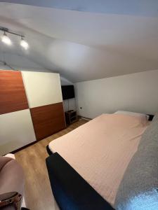 a small bedroom with a bed and a tv at Apartman D&D in Vukovar
