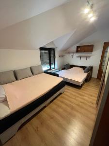 a bedroom with two beds and a couch at Apartman D&D in Vukovar