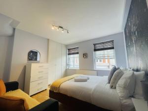 a bedroom with a large bed and a dresser at The Hampstead Residence in London