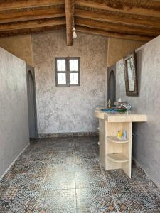 een badkamer met een wastafel en een aanrecht in een kamer bij Authentique berber Camp in Mhamid