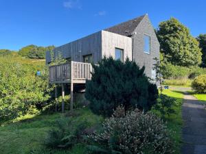 a house with a deck on the side of it at mill house steading overlooking the sea and mull in Bonnavoulin