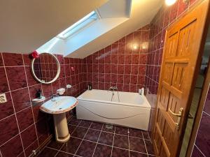 a bathroom with a white tub and a sink at Apartman D&D in Vukovar