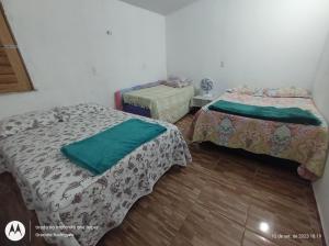 um quarto com 2 camas e piso em madeira em Suíte GUARAMIRANGA no Sítio em Guaramiranga