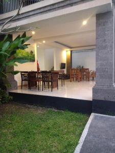 une salle à manger avec des tables et des chaises en bois dans l'établissement purnama fullmoon resort, à Ubud