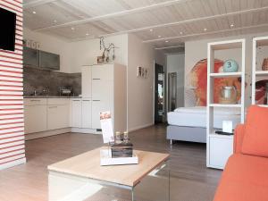 a living room with a table and a kitchen at Butze Ferienapartment in Büsum