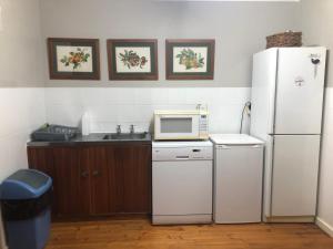 a kitchen with a white refrigerator and a microwave at Emma's Beach Cottage in Great Brak River
